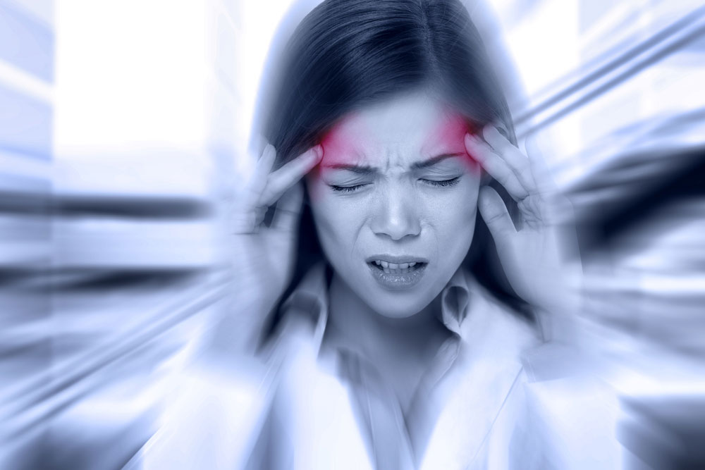 woman with a migraine holding her temples