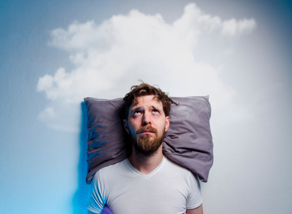 man with a pillow and clouds in the background